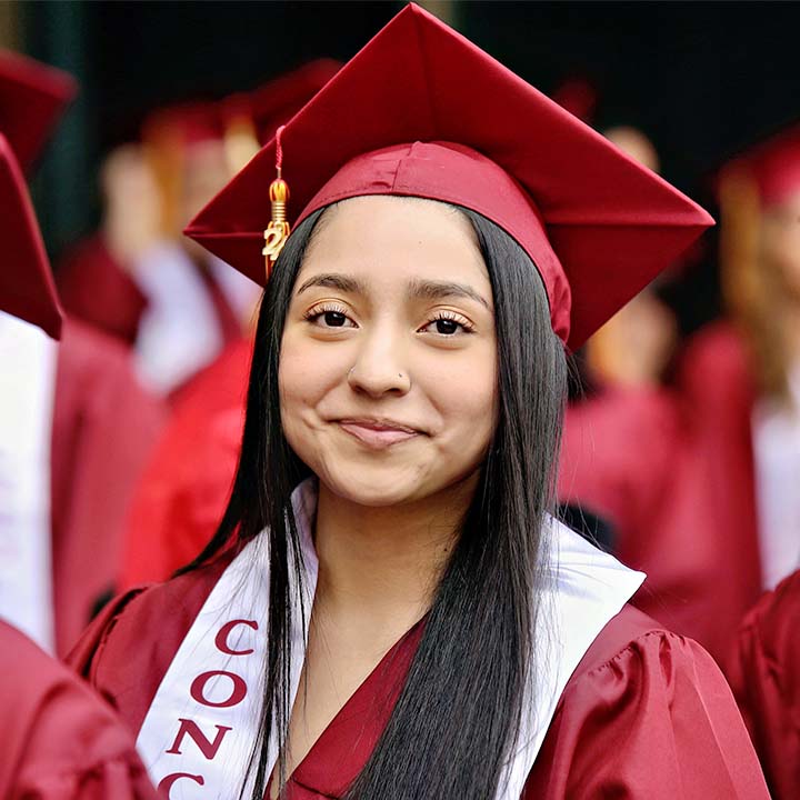 Woman poses for picture in CCA graduation cap and gown.