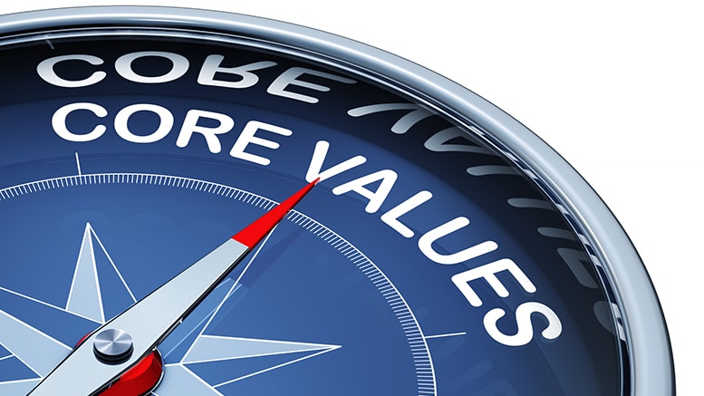 Close-up of a blue compass with a red needle pointing toward the words 